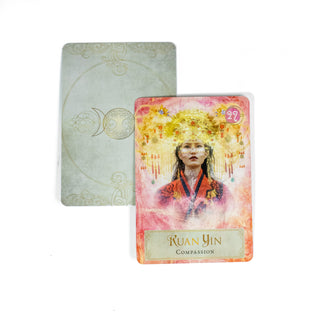Kuan Yin Compassion card from the Goddess Power Oracle Deck shows a woman with an elaborate golden headress and red robe. A second card behind it shows the back of the deck, which is grey with a triple moon symbol.