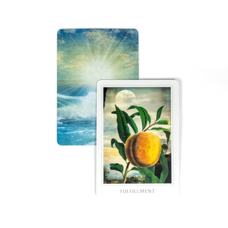 The Fulfillment card from the Sacred Destiny Oracle Deck shows a ripe peach on a tree with a full moon behind it. A second card behind it shows the back of the deck of cards, which is bright rays illuminating the ocean.
