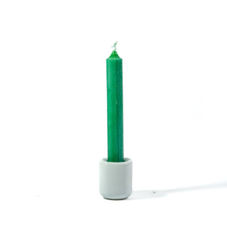 Green chime candle for spellwork and intention setting, set in a white ceramic candle holder with white background.