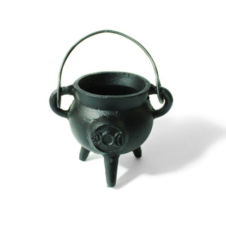 Black cast iron cauldron with a handle on three legs. A triple moon symbol is engraved on the front.