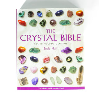 Cover of the Crystal Bible a Definitive Guide to Crystals by Judy Hall. Book is square and has images of dozens of different crystals of all shapes and colors. 