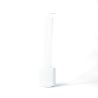 White chime candle for spellwork and intention setting, set in a white ceramic candle holder with white background.