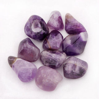 Close up of tumbled Amethyst pocket stones showing different shades of purple from light to dark.