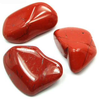 Close up of three tumbled red jasper stones in vibrant red.