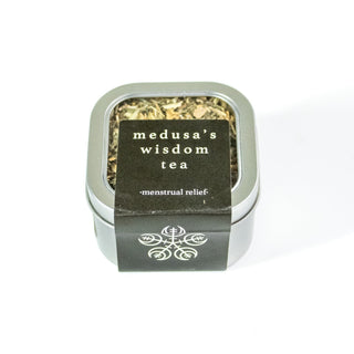 Medusas wisdom herbal tea in a square aluminum tin. The cover is clear to show the loose herbs inside. Label is black.