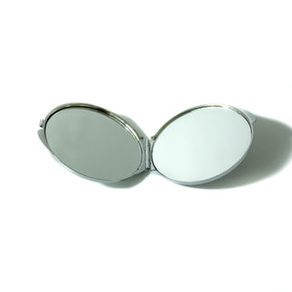 Open double sided compact mirror, circular and silver. 