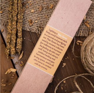 Back of the Palo Santo incense sticks box with product description. Three thick incense sticks are shown next to it.