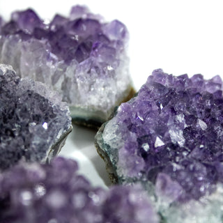 Multiple pieces of raw amethyst with varying colors of purples.
