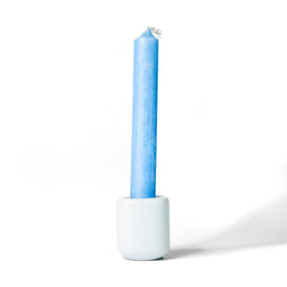 Blue chime candle for spellwork and intention setting, set in a white ceramic candle holder with white background.