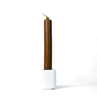 Brown chime candle for spellwork and intention setting, set in a white ceramic candle holder with white background.