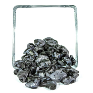 Several indigo gabbro tumbled pocket stones, light blue with black spotting, in a glass bowl.