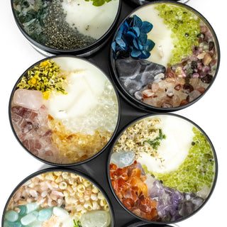 Five Nymph and Satyr scented candles with variety of crystals and herbs. 