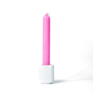 Pink chime candle for spellwork and intention setting, set in a white ceramic candle holder with white background.