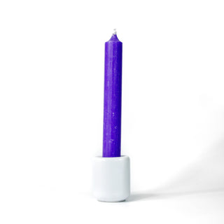 Purple chime candle for spellwork and intention setting, set in a white ceramic candle holder with white background.