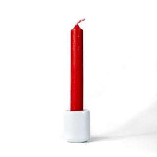 Red chime candle for spellwork and intention setting, set in a white ceramic candle holder with white background.