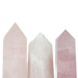 The top half of three rose quartz generators showing natural variation in color from light to medium pink.