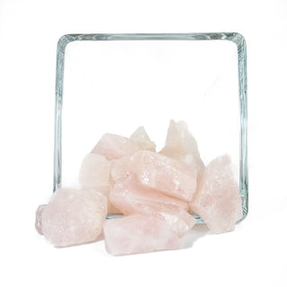 Several pieces of raw rose quartz in varying sizes and natural shapes. Natural stone is light pink.