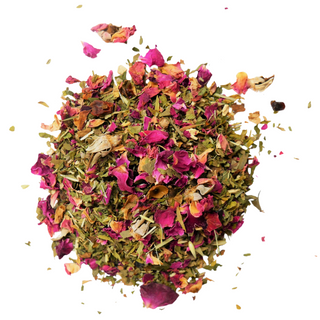 Organic loose leaf tea with pink dried rose and green herbs.