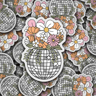 Sticker is a grey scale discoball with pink, orange and white flowers coming out of it. 