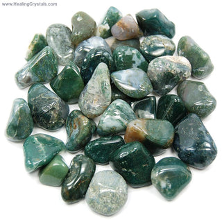 Several tumbled moss agate pocket stones showing natural variation of color from dark green to very light green.
