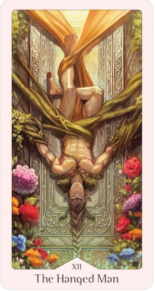 The Hanged Man Card from the Heavenly Bloom Tarot Deck shows a person hanging upside down suspended by green tree branches and a golden cloth. Their long braided hair hangs from them. THere are colorful flowers around the border.