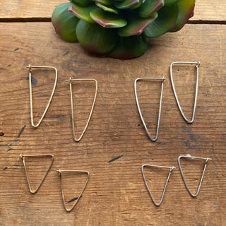 Four sets of triangular hoop earrings, showing the larger size in gold and silver at the top and the smaller earrings below.