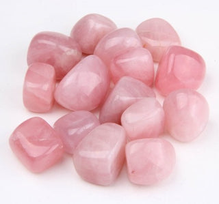 Several tumbled rose quartz pocket stones showing natural variation in color from very light to deep pink.